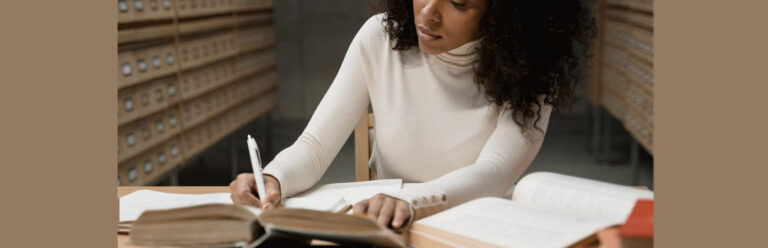Adult academic woman in university library writing her thesis