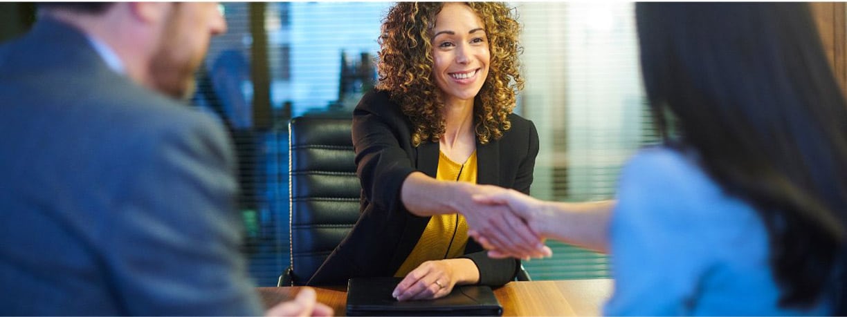 Sollicitatiegesprek Engels – Trainer and client practicing shaking hands in a job interview.